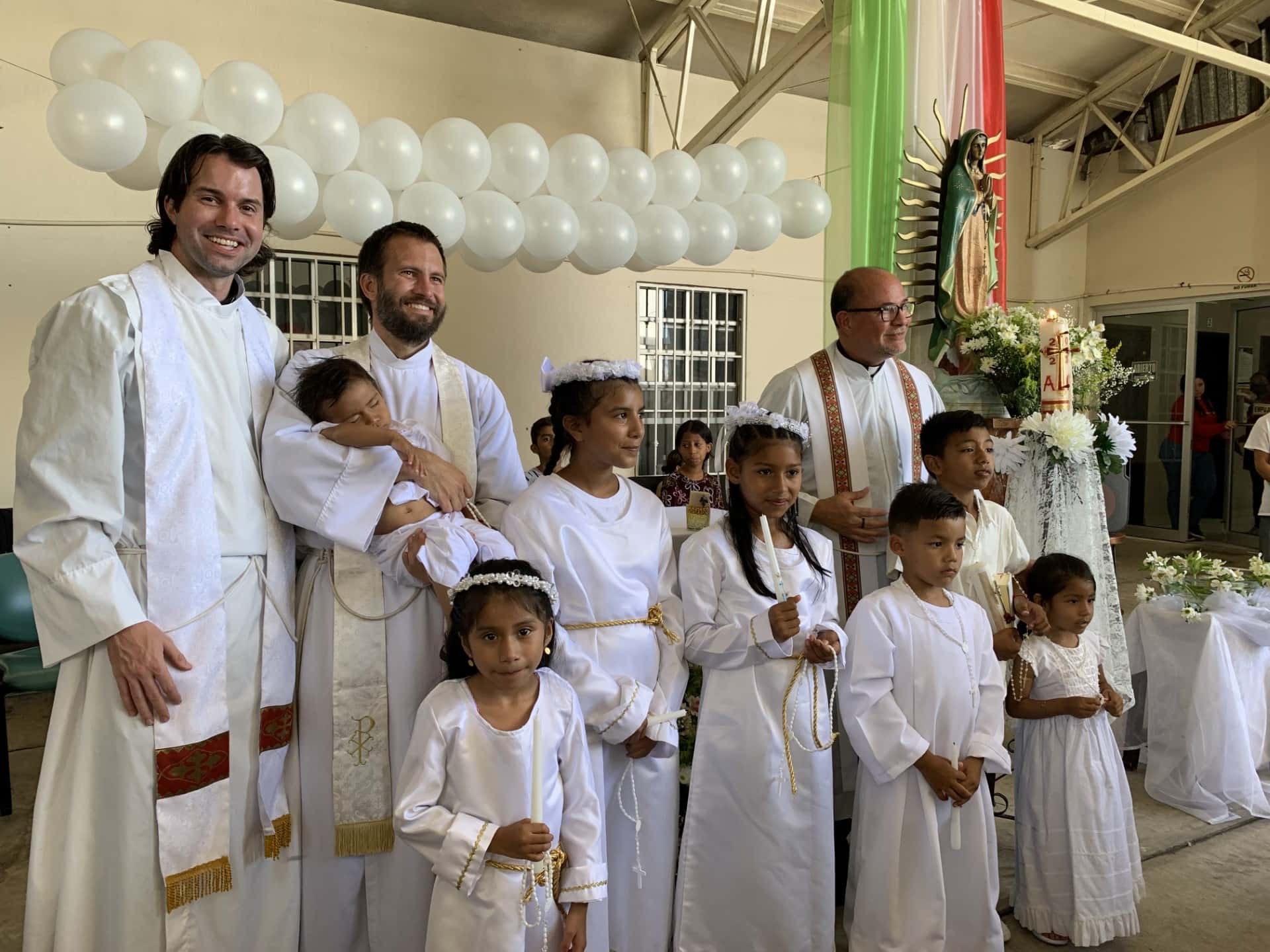 Jesuit Fathers Louie Hotop, Brian Strassburger and Flavio with children receiving sacraments Feature Image